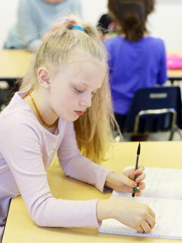 Elementary student writing in notebook
